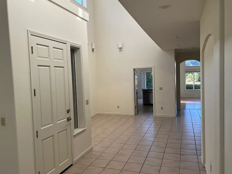 Bright dining room with tall ceilings and windows near ceilings
