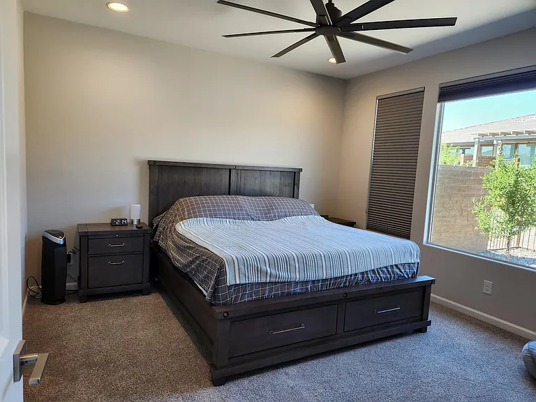 Primary bedroom with nightstands, dresser and ceiling fan