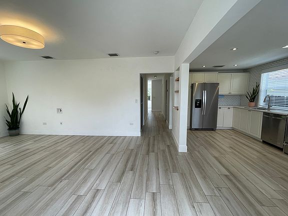 Spacious entryway and living room. Living room light is on a wifi-enabled smart switch. Wifi not included