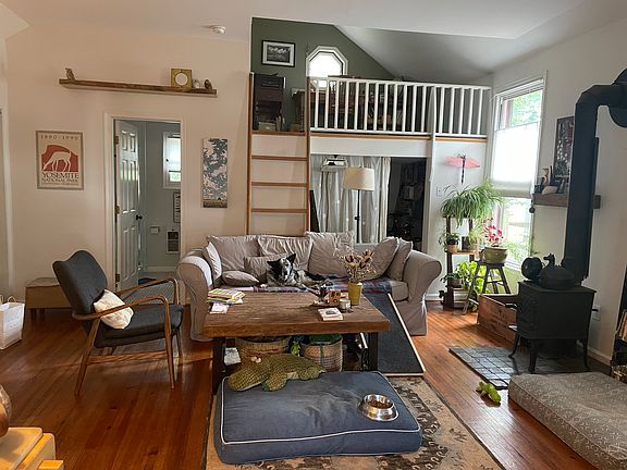 Main living area with loft/office upper right, door to bathroom on left and opening to back storage area on right.