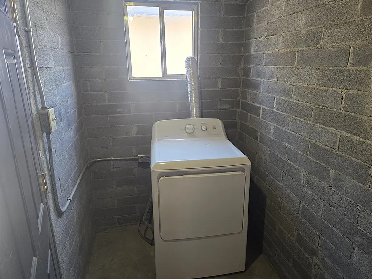 Storage room with electric dryer.