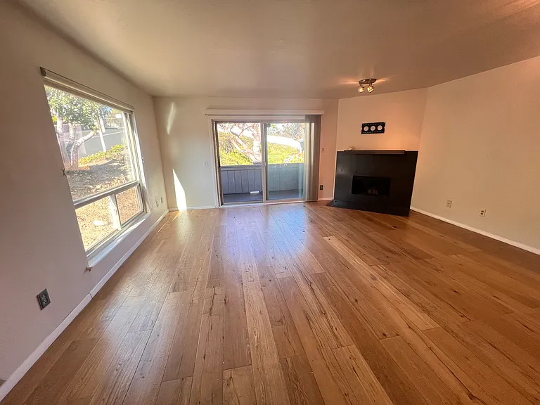 Living room with wood burning fireplace, 1 of 2 balconies and tons of natural light