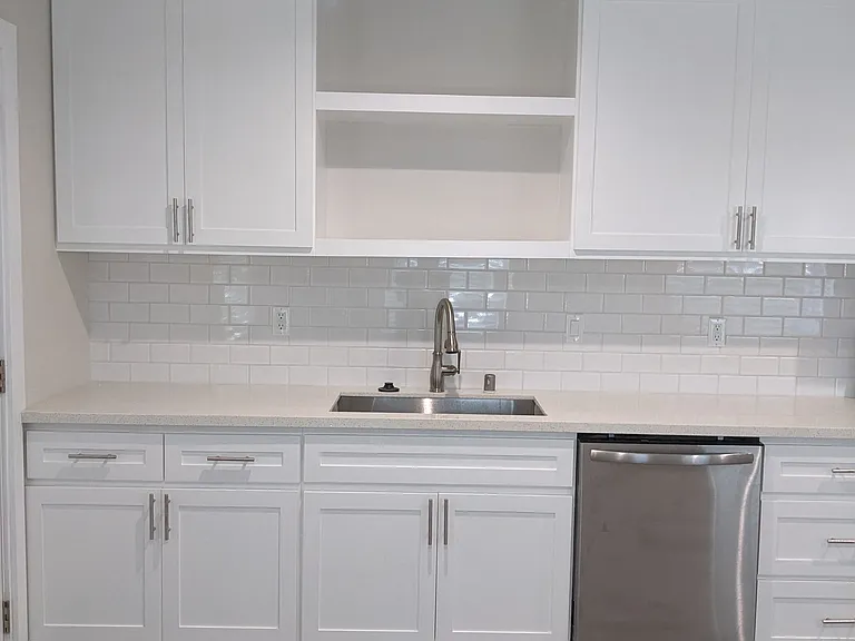 Lots of bright white kitchen cabinets in apartment unit at The Hardison in Pasadena, California.
