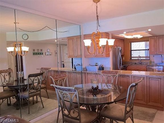 Dining room with mirrored wall and kitchen