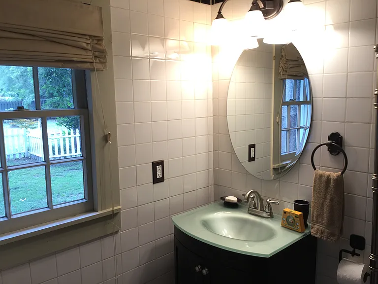 Garden-facing window fills the primary bath with natural light and views of the private yard.
