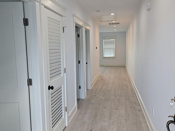 Front door opens to hallway. Main living area and kitchen are in the rear, close to a very large deck.