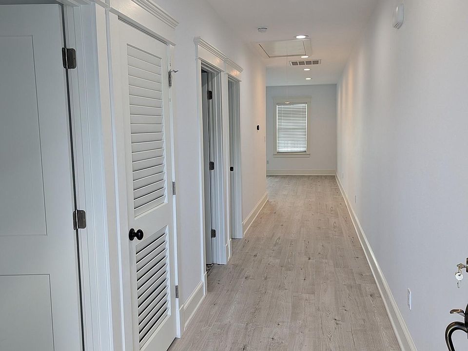 Front door opens to hallway. Main living area and kitchen are in the rear, close to a very large deck.