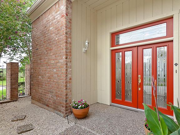 A beautiful courtyard highlighted by brick columns and wrought iron fencing is just to the left of t
