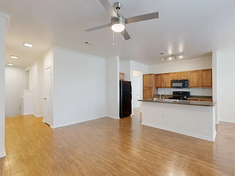 Apartment kitchen and dining room with wood-style flooring.