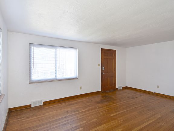 Spacious living room with refinished original hardwood flooring.