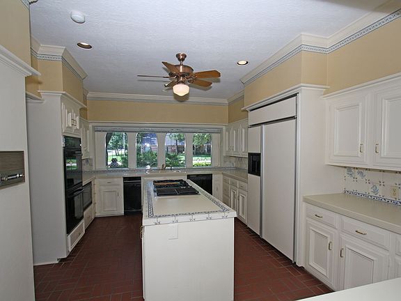 Island kitchen with GE Monogram fridge, GE Profile double ovens, gas island co
