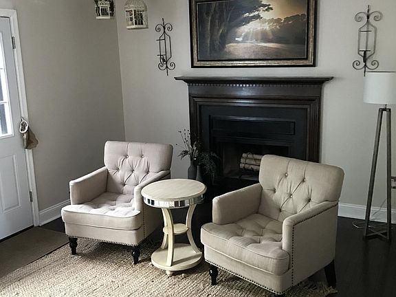 Hardwood floor living room with wood-burning fireplace. 