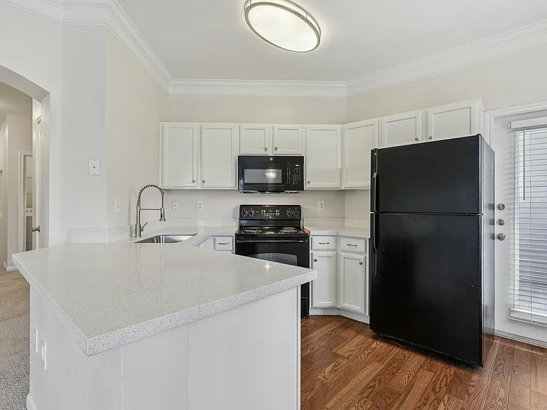 Modern kitchen with sleek white cabinets, black appliances, and elegant countertops. Modern kitchen with sleek white cabinets, black appliances, and elegant countertops.