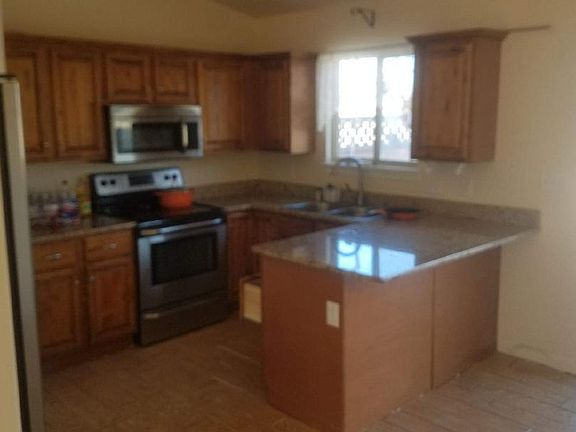 Kitchen with stainless steel appliances. New tile floor and granite countertops. Vaulted ceiling in kitchen and living room. Large pantry for storage