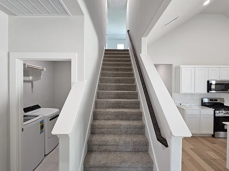 Elegant staircase leading to the second-floor living areas and additional bedrooms