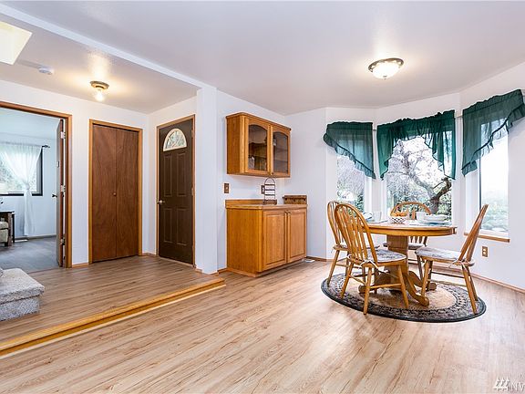 Dining off of den shows off custom built sideboard and china cabinet.  Front door a step up and sneak peak at sitting room to downstairs suite.