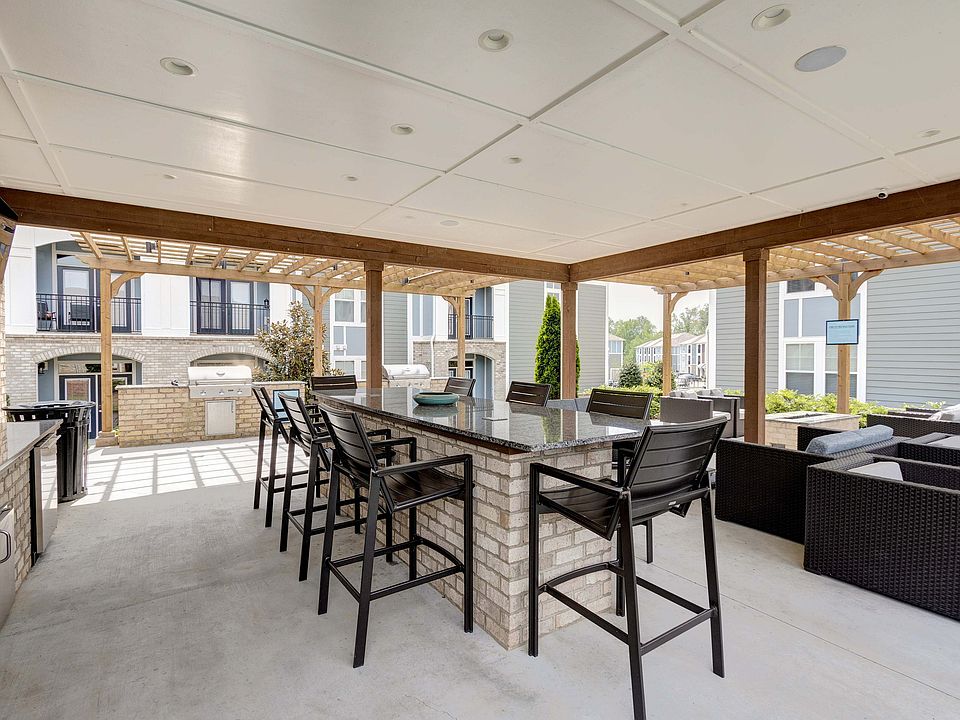 Experience stylish outdoor living with this elegant patio complete with a sleek bar and lounge area.