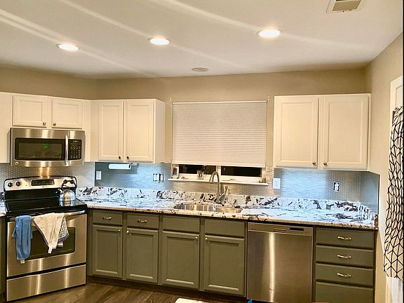 Kitchen with touch faucet and motion activated/dimming under cabinet lights. Electric stove.