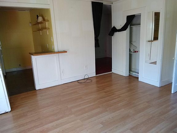 Living room, looking toward kitchen, bedroom doorway, and living room closet.