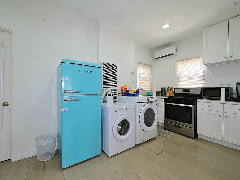 Fully furnished living room with upgraded kitchen, appliances, and laundry machines
