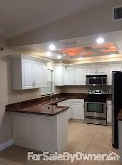Kitchen : Stainless steel appliances with granite countertops. Coffered ceiling with fan.