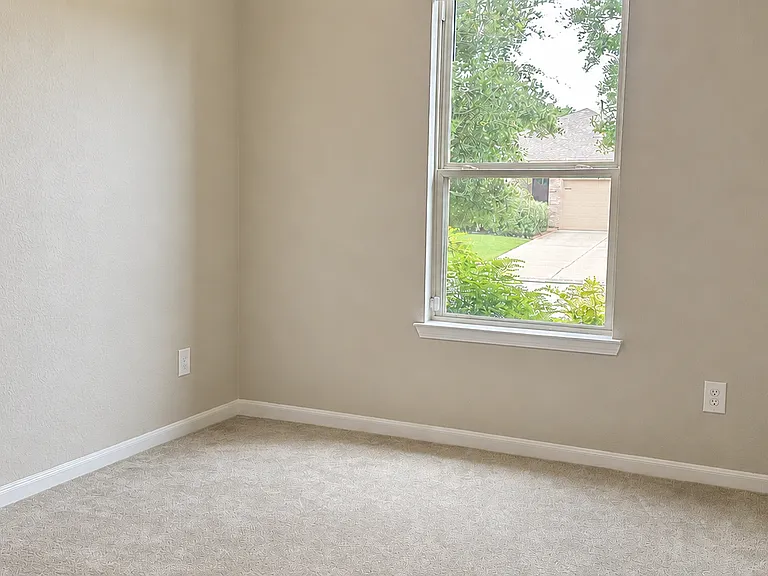 Bedroom #2 with soft natural light and neutral finishes