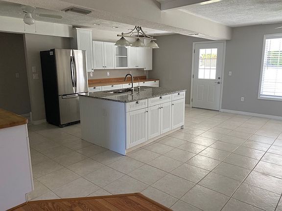 Spacious kitchen with plenty of counter space and open to area that could be family area, eat in kitchen. Large sunny windows and doror that leads to patio