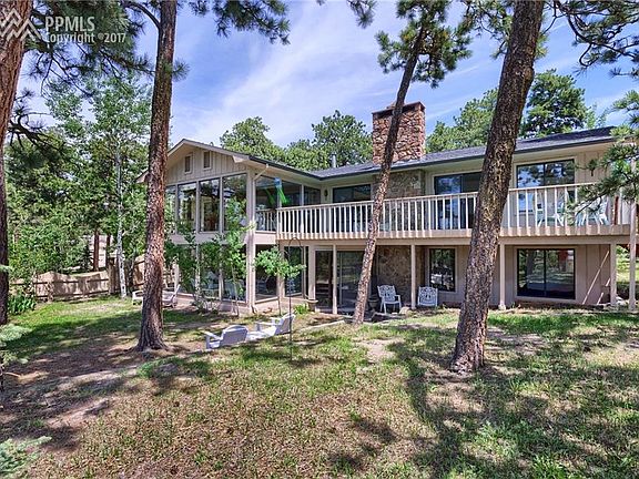 Rear of home with large deck and walk out from lower level solarium