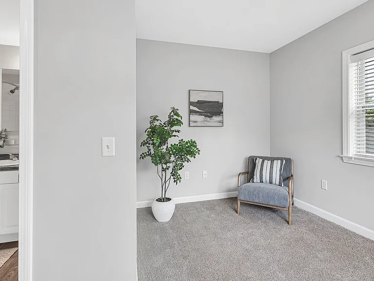 The ultimate college space - a cozy bedroom with plush carpet, large window, and ensuite bathroom access for ultimate convenience.