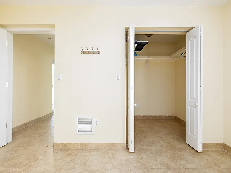 Bedroom closet on the right and hallway to bathroom, kitchen, and living room on the right