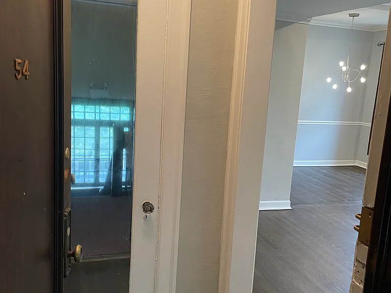 View from front door of coat closet (mirrored door) and living room