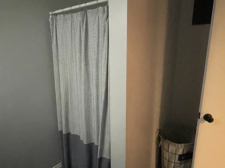 Stand-up shower in bathroom off the kitchen. Tile floor.