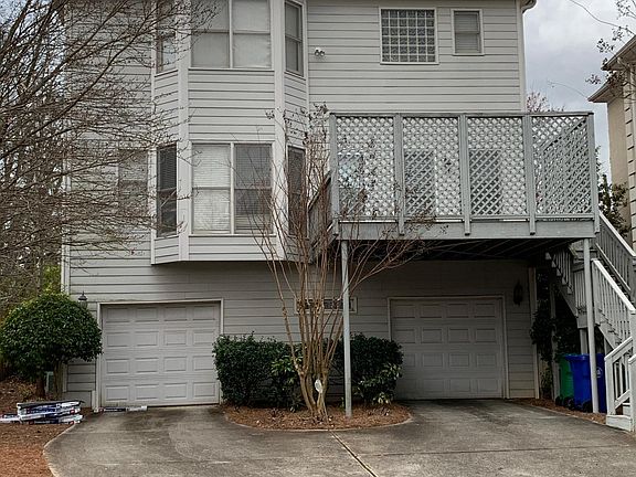 Backside of the house shows 2 car garage, large driveway for more cars, as well as a second story patio. Bay windows in the Kitchen give way to amazing light in the breakfast nook.