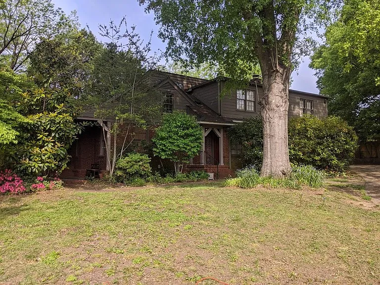Two Story House showing Side Entrance, next to Parking Area large enough for four cars.