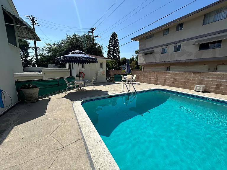 Pool with free community laundry facility behind it.