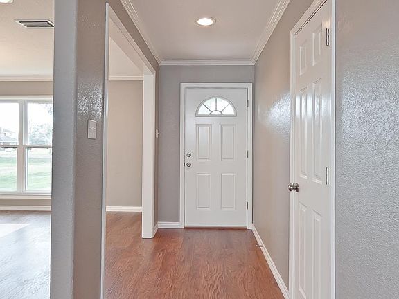 A view of the entry area.  This home just had new laminate flooring installed, fresh designer paint, crown moulding, all new light fixtures, plumbing fixtures and stainless kitchen appliances!  Granite countertops in both bathrooms & kitchen too!