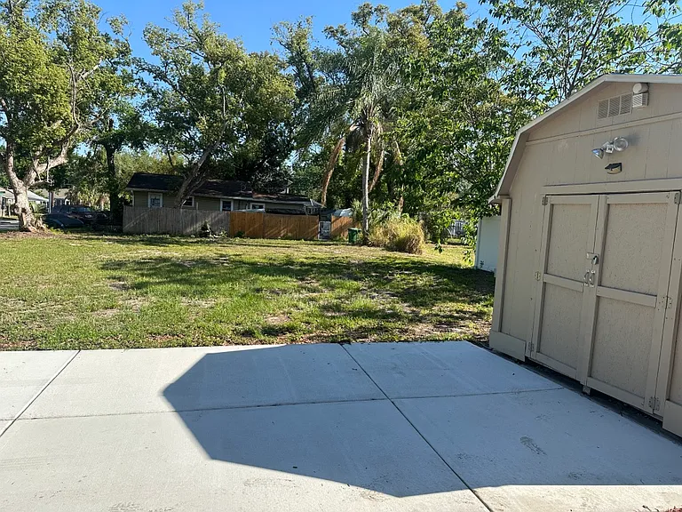 Outdoor shed and large (3 car) paved driveway.