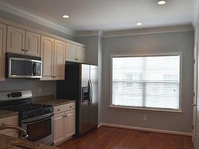 Main floor Kitchen features pantry to right of large window in the photo, hardwoods and granite, all stainless appliances.