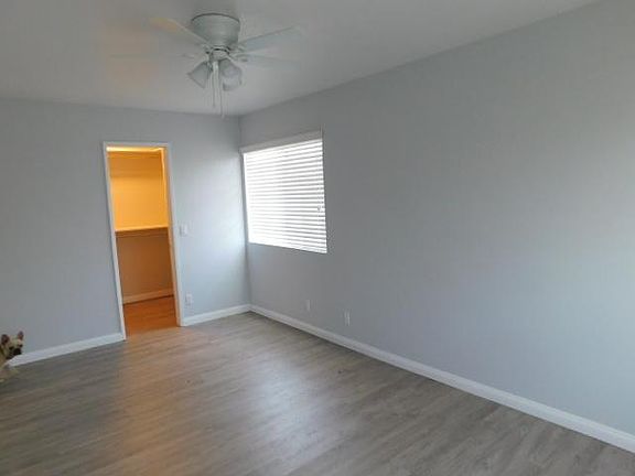 Master Bedroom Walk in Closet with Closet Organizers & ceiling fan in bedroom