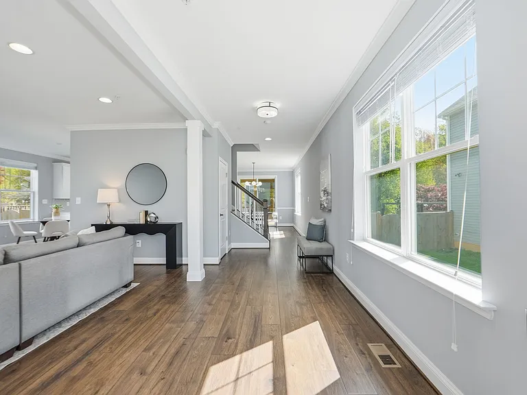 Beautiful entryway with tons of natural light, hardwood flooring and opening to the living room with gas fireplace.