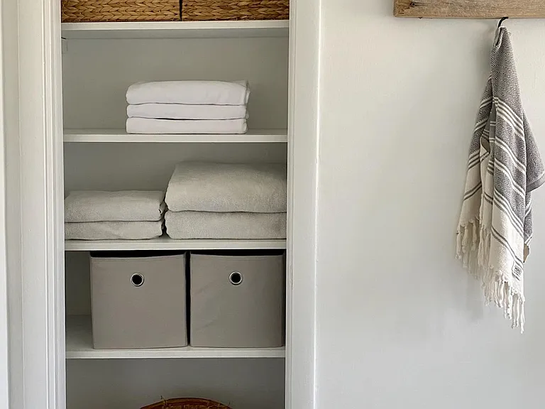 Ample linen and toiletry storage in master bath.