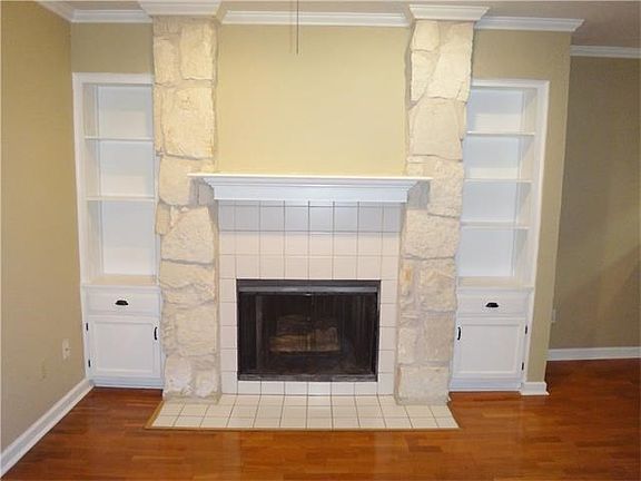 Living room with built in storage and wood burning fireplace