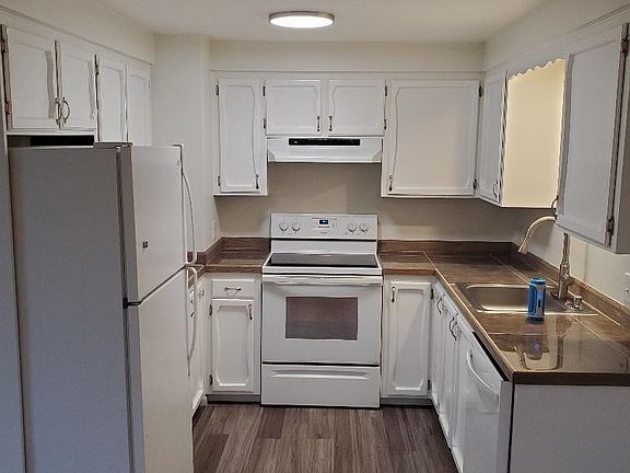 Kitchen with newer dishwasher, faucet, garbage disposal, stove, ceiling lights.