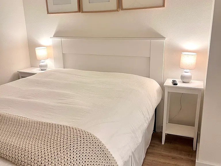 Mater bedroom included a queen bed, window AC unit, and nightstands w/lamps.