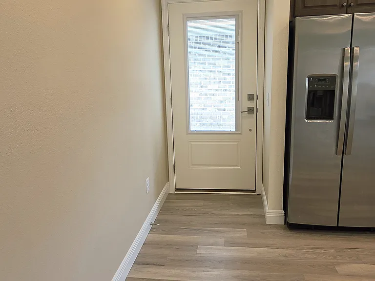 Side entry door leading around back to a concrete patio