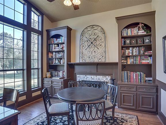 Built in bookcases on each side of wood burning fireplace cozy study with chair railing, wood flooring and large bright open windows!!