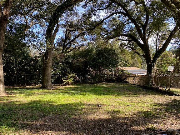 Back yard of property, nice and private. Concrete slab in rear backyard to the left of this photo