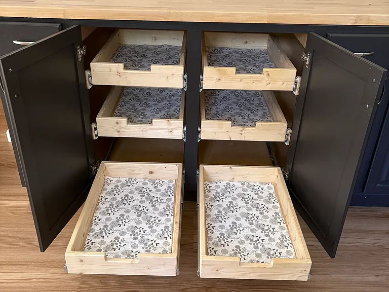 Cabinets feature custom-built roll-out drawers that maximize storage and make everyday organization effortless.