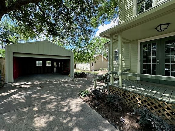 The Dining Porch with french doors, the Storage Garage with its door raised, and the back Garage beyond.