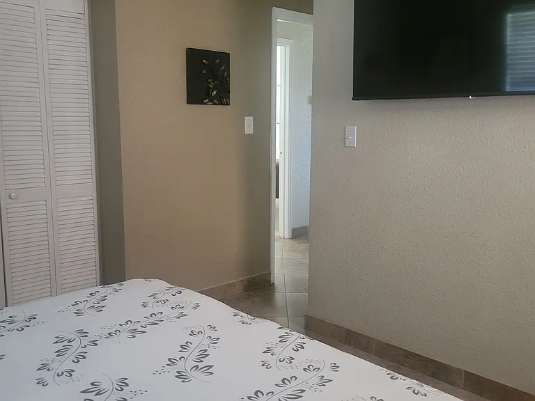 Foot of King bed in Master bedroom and a 55-in. tv with streaming service.